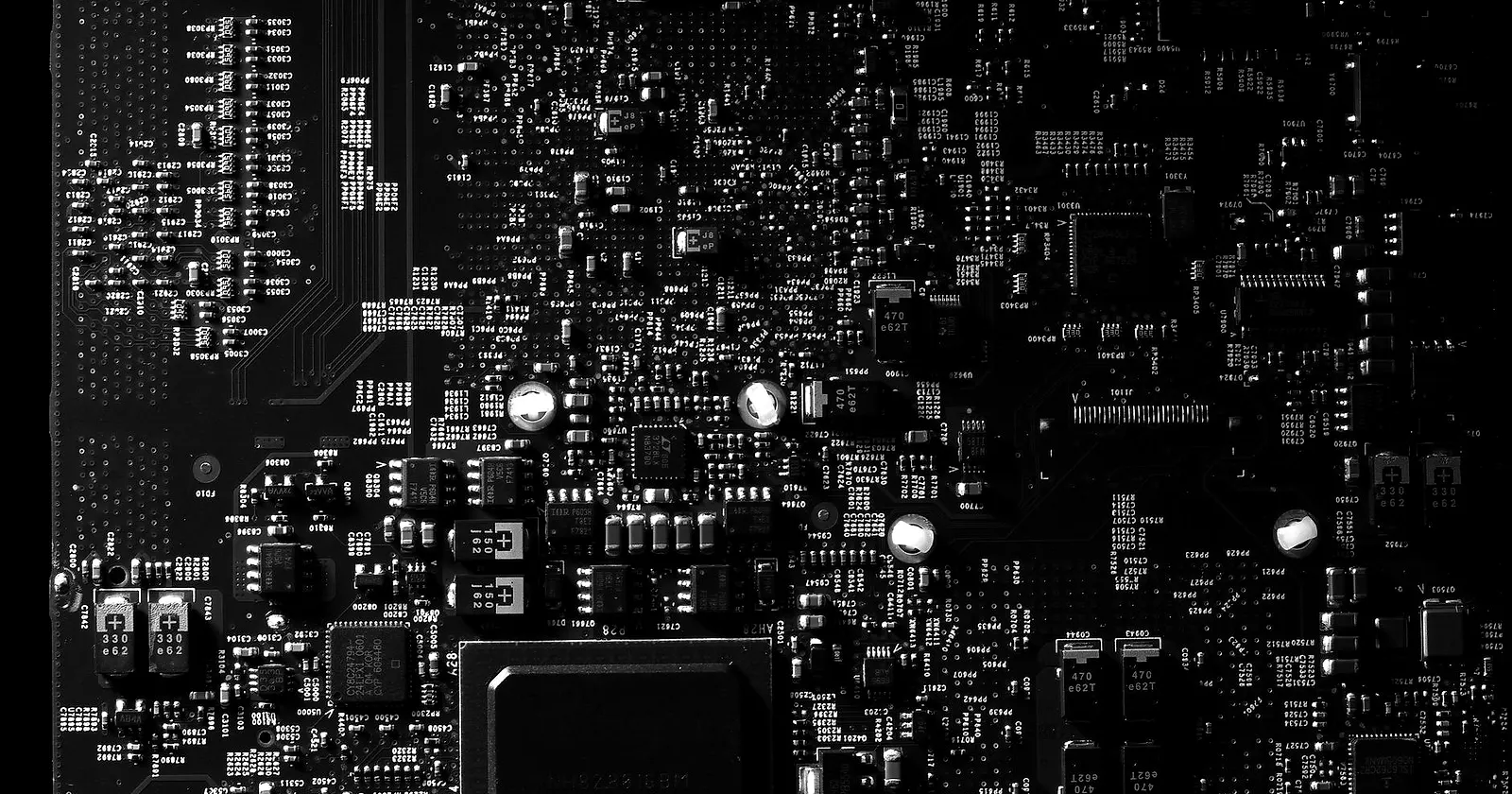Close-up of a dark circuit board with fine white traces and components
